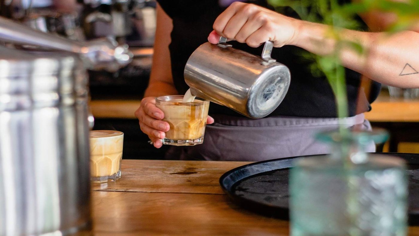 Backpacker serving coffee in Australian cafe