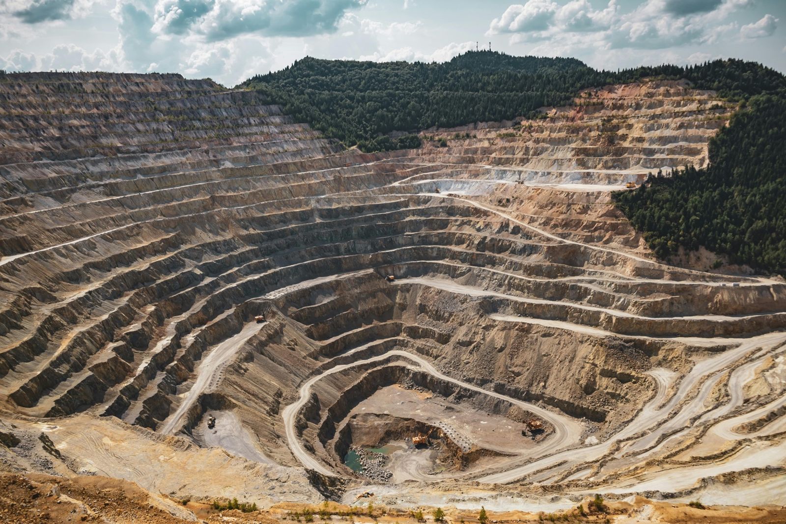 Open-cut mining pit with multiple levels and trucks