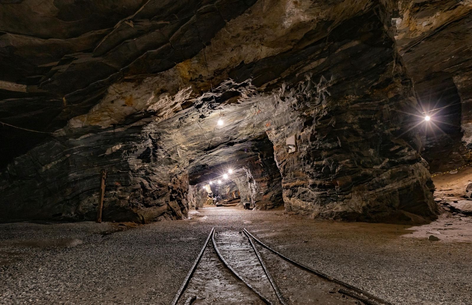 Underground tunnel in a mine with tracks and lights